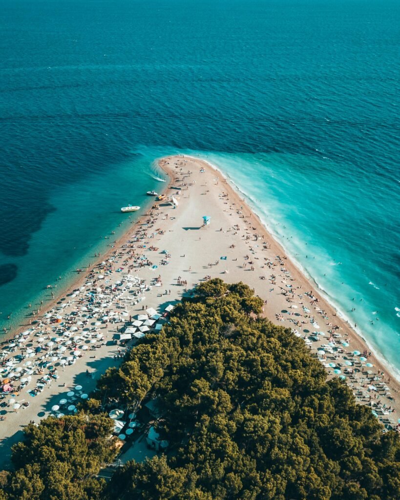 Stunning aerial view of Zlatni Rat beach in Bol, Croatia, showcasing turquoise waters and sandy peninsula.