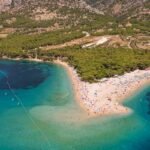A stunning aerial view of Zlatni Rat beach with turquoise waters and lush landscapes in Croatia.