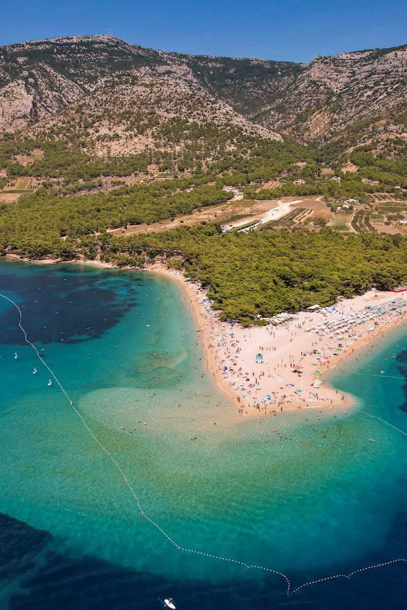 A stunning aerial view of Zlatni Rat beach with turquoise waters and lush landscapes in Croatia.