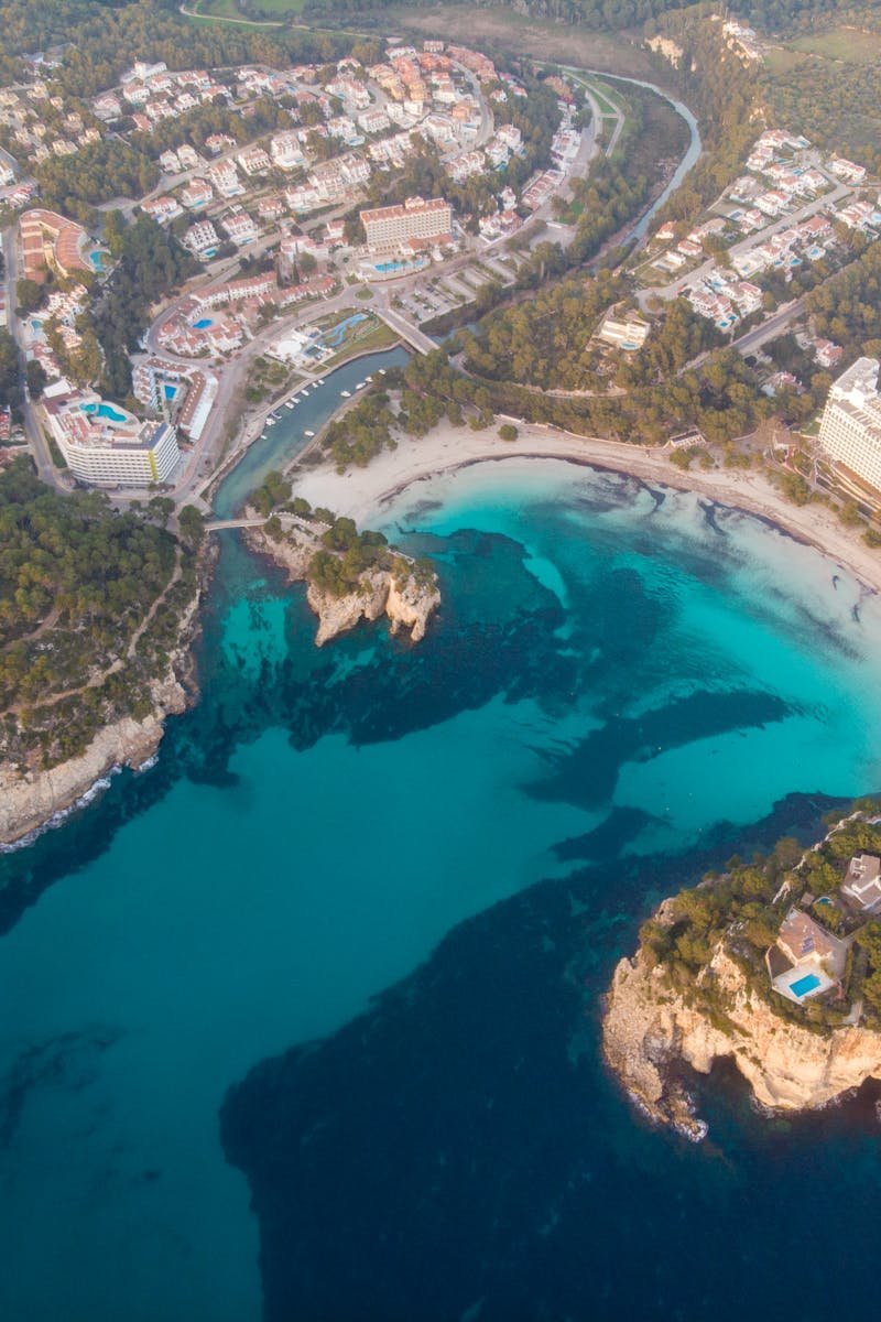 Stunning aerial view of Ciudadela de Menorca, highlighting its beautiful coastline and vibrant blue sea.